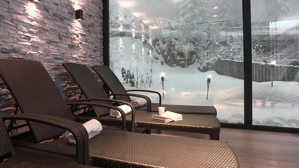 Dolomites wellbeing: A serene wellness area featuring comfortable lounge chairs, with a view of snowy outdoor scenery through large windows, creating a tranquil atmosphere.